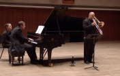 Solo trombone performance with collaborative pianist on stage.