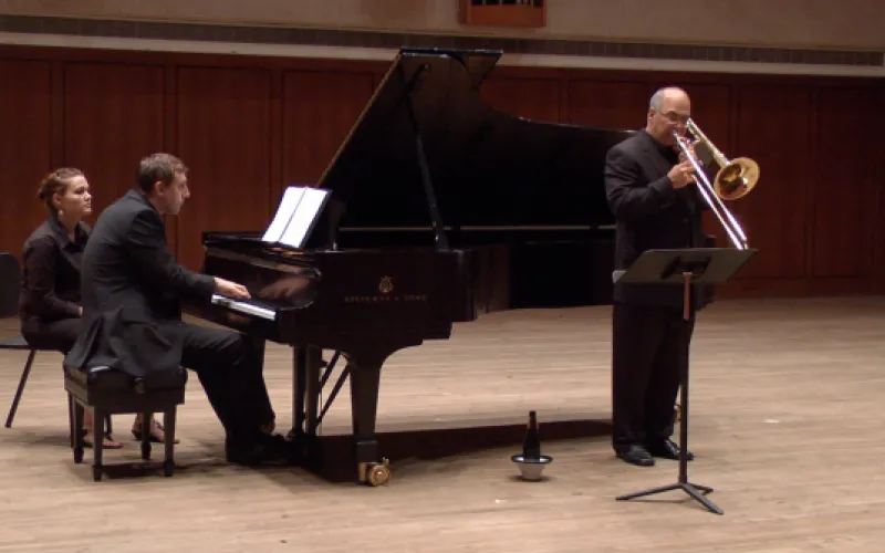 Solo trombone performance with collaborative pianist on stage.