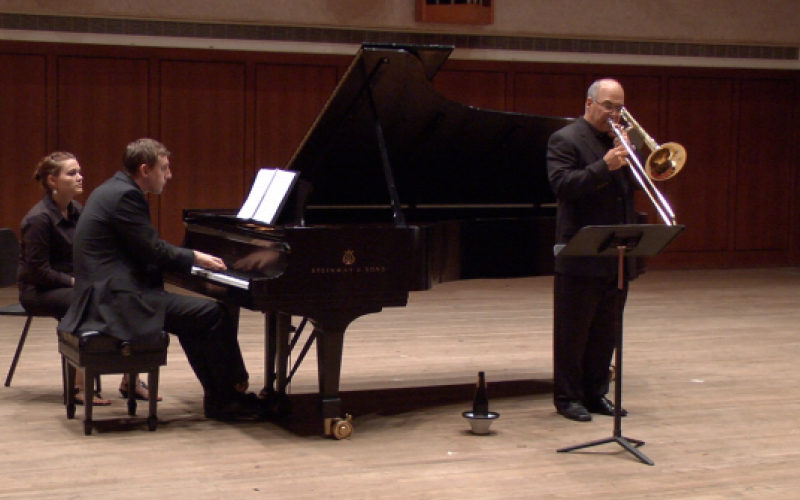 Solo trombone performance with collaborative pianist on stage.